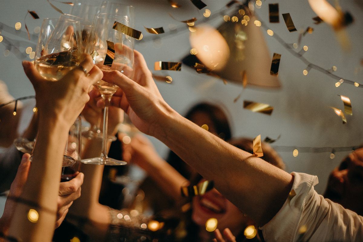 Brinde de confraternização com taças e confete dourado